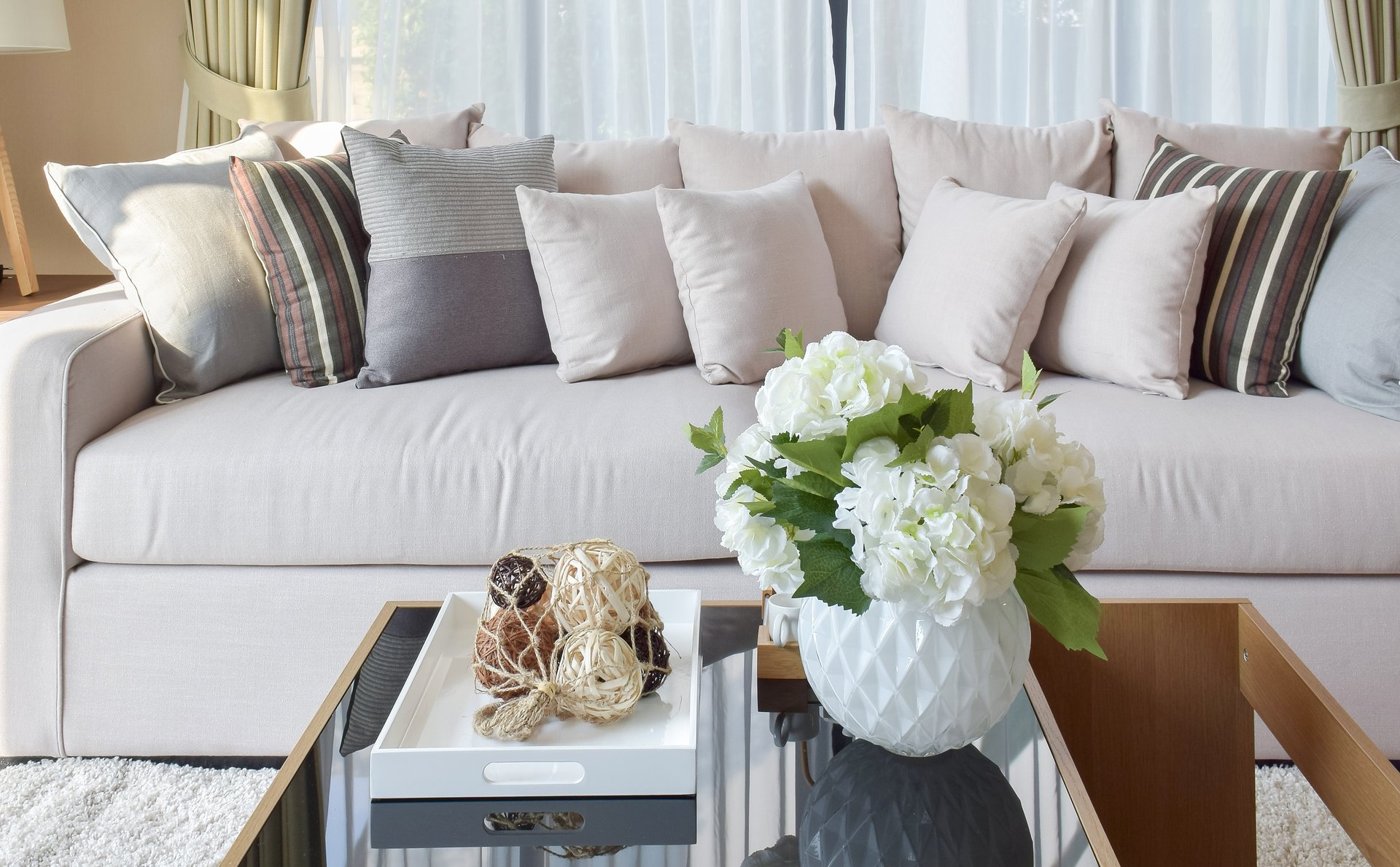 a living room filled with furniture and vase of flowers on a table